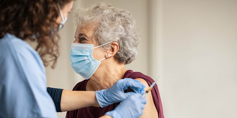 An older woman gets a vaccine.