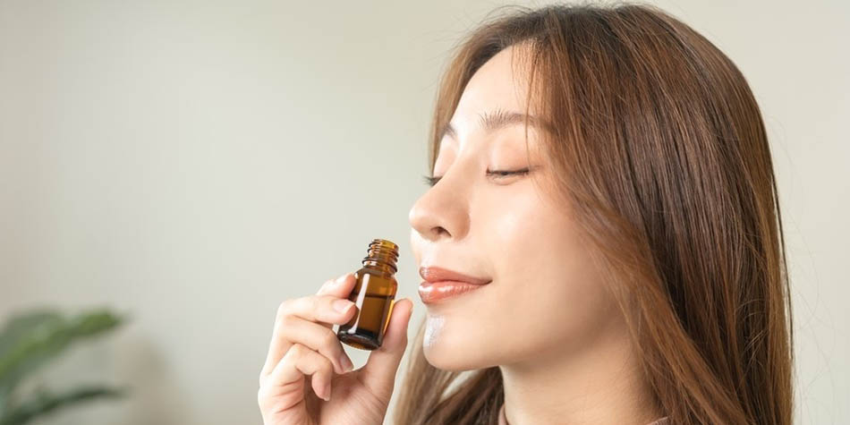 A woman smells an essential oil.